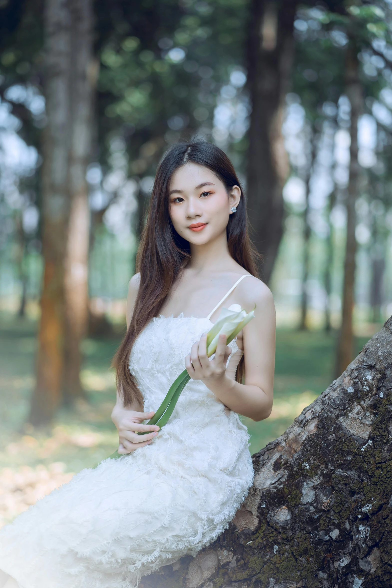 a  in an elegant white gown is holding a bouquet of flowers