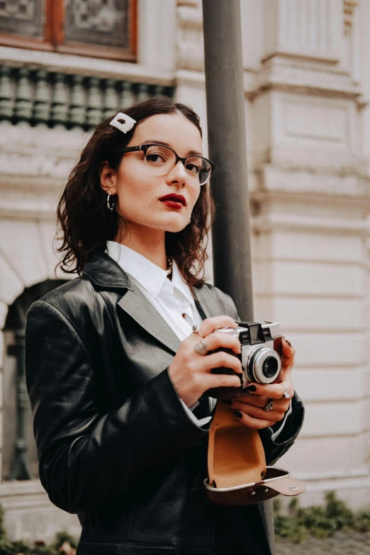 a woman standing next to a light pole holding a camera