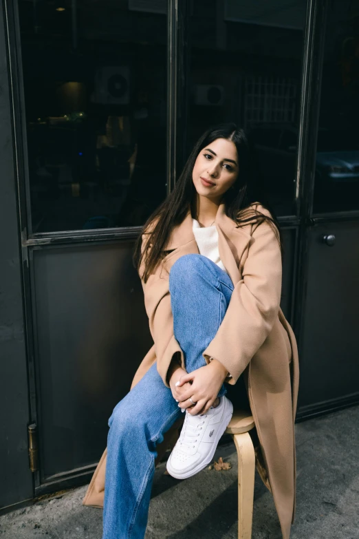 a woman in blue jeans is posing for the camera