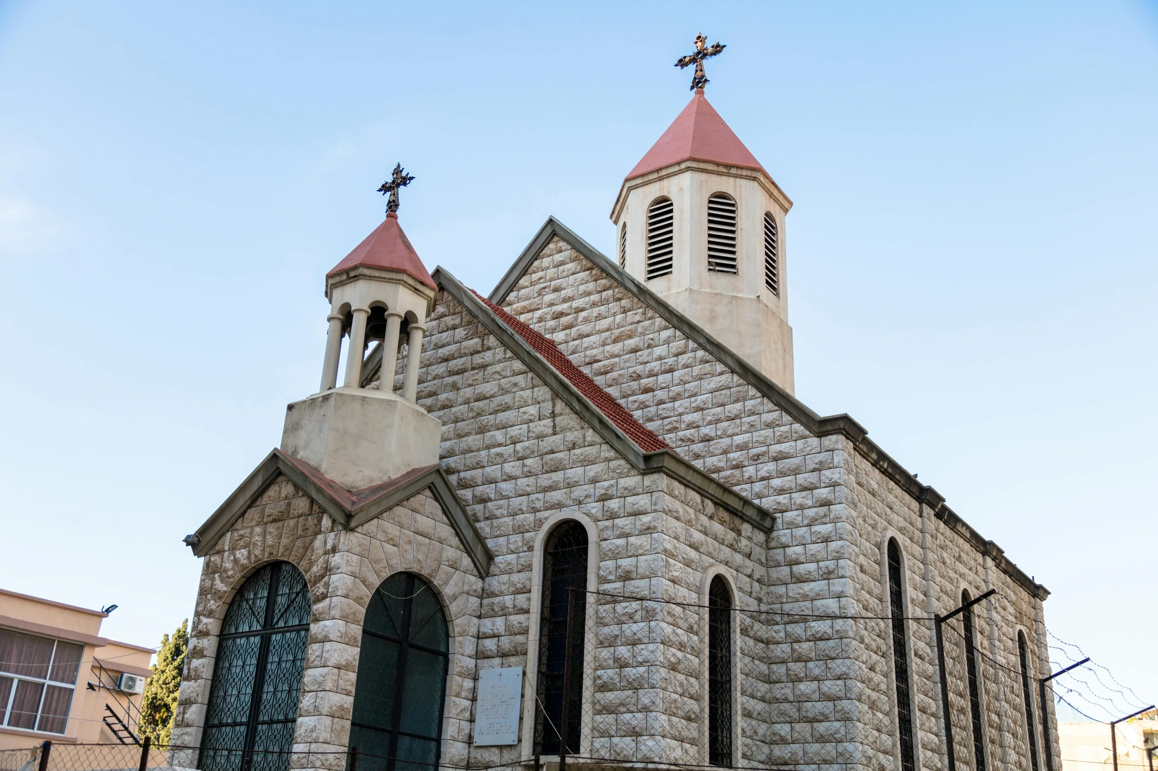 a church that has a steeple and two crosses on the front