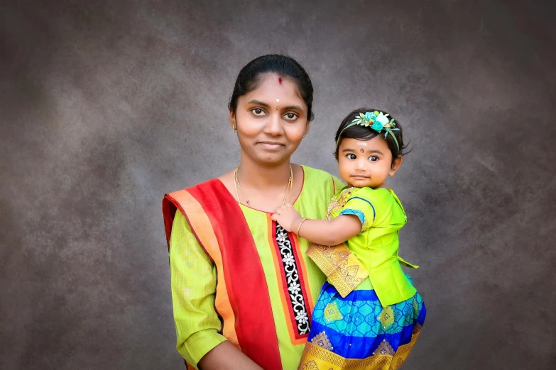 a woman holding a little girl with one hand in her other