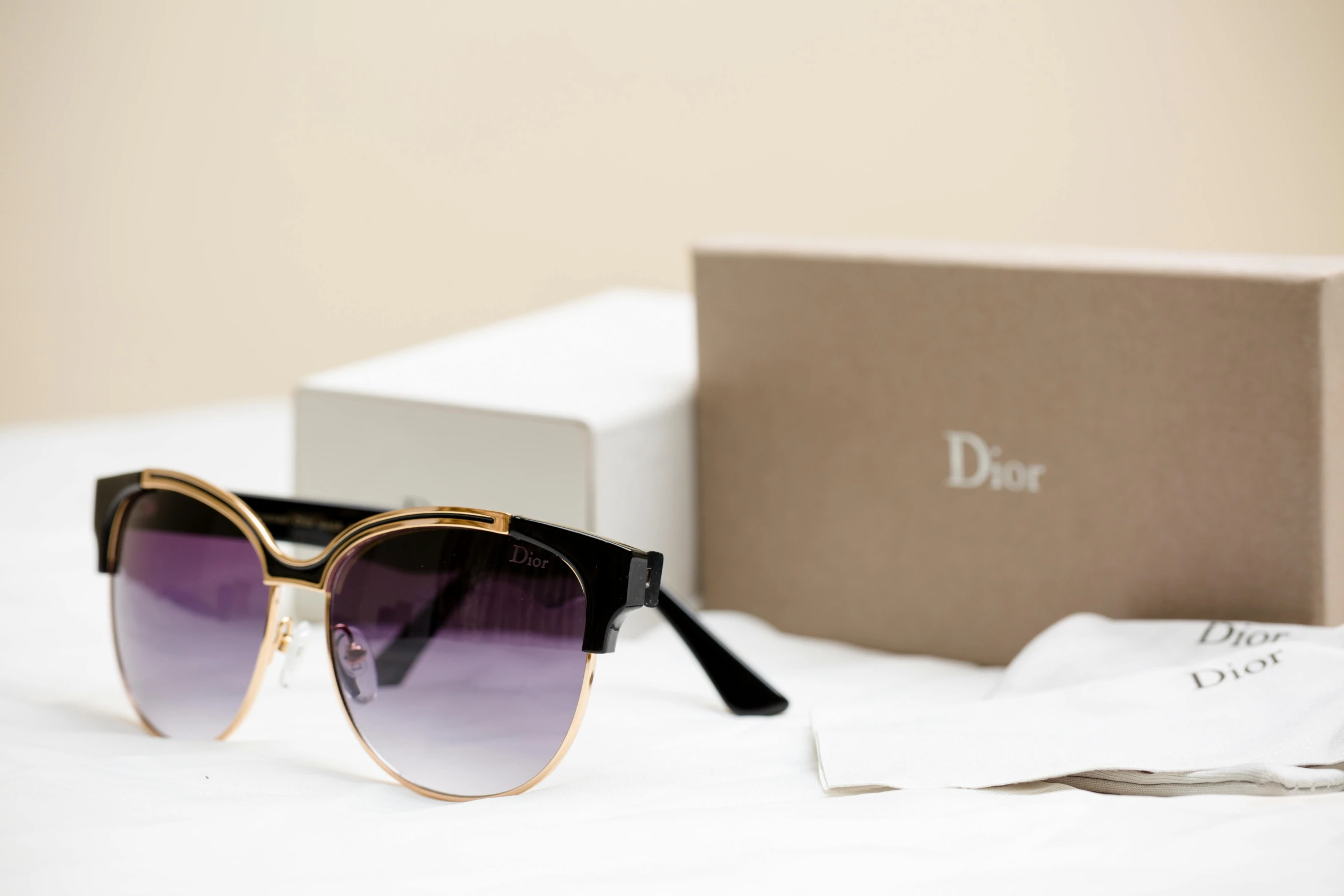 a small square frame sunglasses next to a box