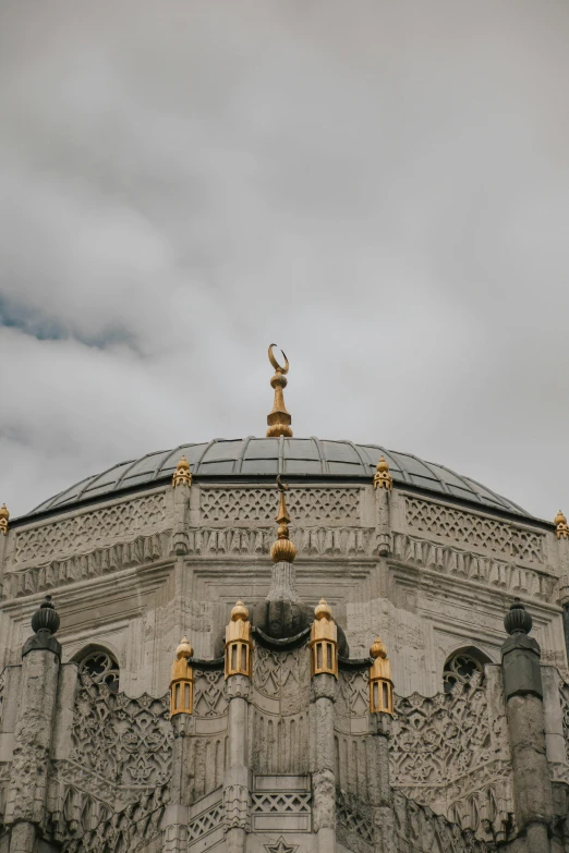 an elaborately designed building has golden gargoyle on the top