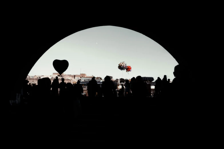 people are in the dark with the heart - shaped balloons being flown