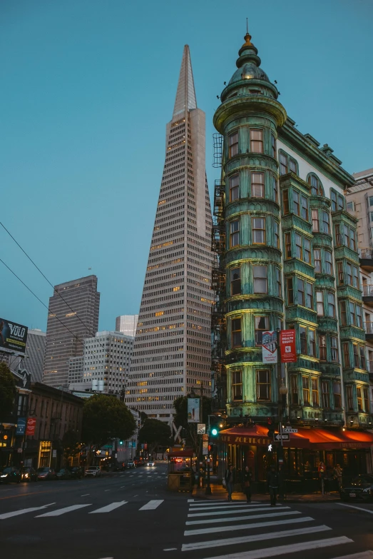 the city intersection is shown at dusk with a church steeple on the corner