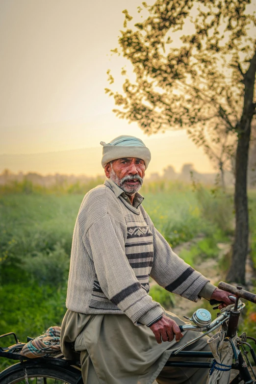 an older man riding a bicycle in the field