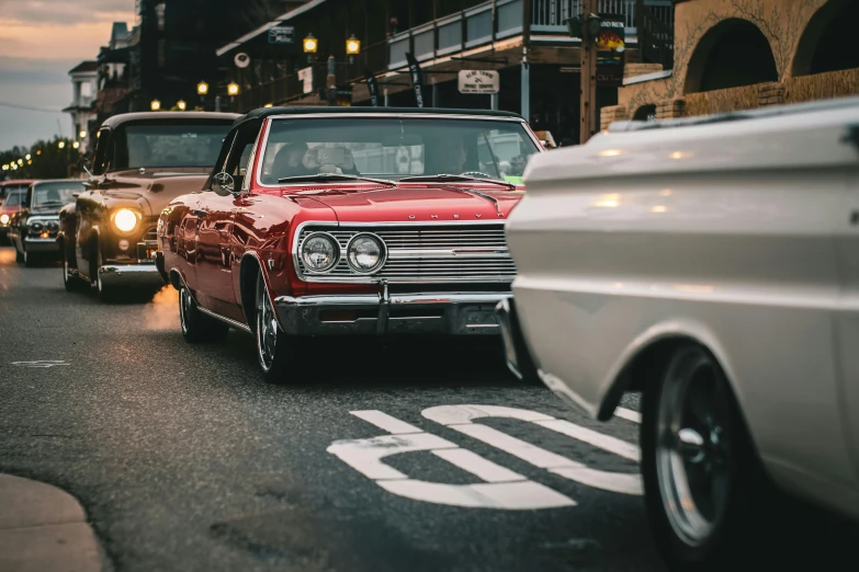 vintage cars line up as they travel down the street