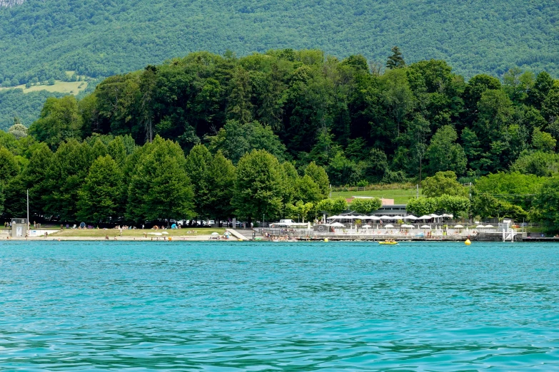 two boats are anchored in the water by trees