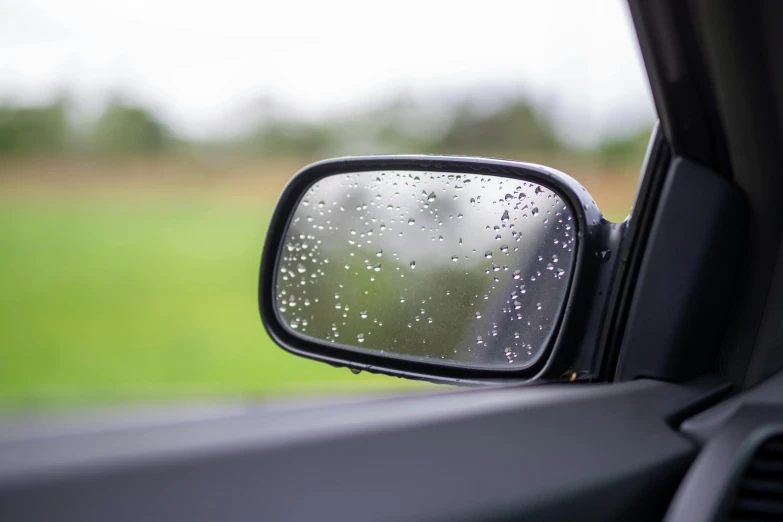 a car mirror with raindrops on it's side