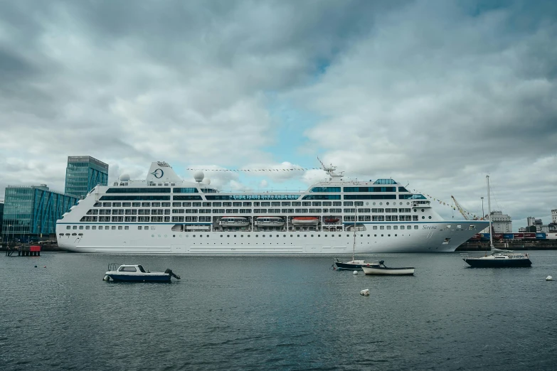 a cruise ship is in the middle of a harbor with other small ships