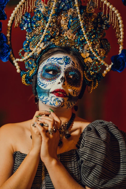 a woman is covered in face paint and jewelry