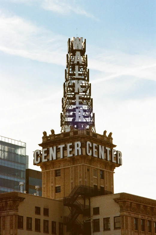 the sign on top of an old building with a giant tower