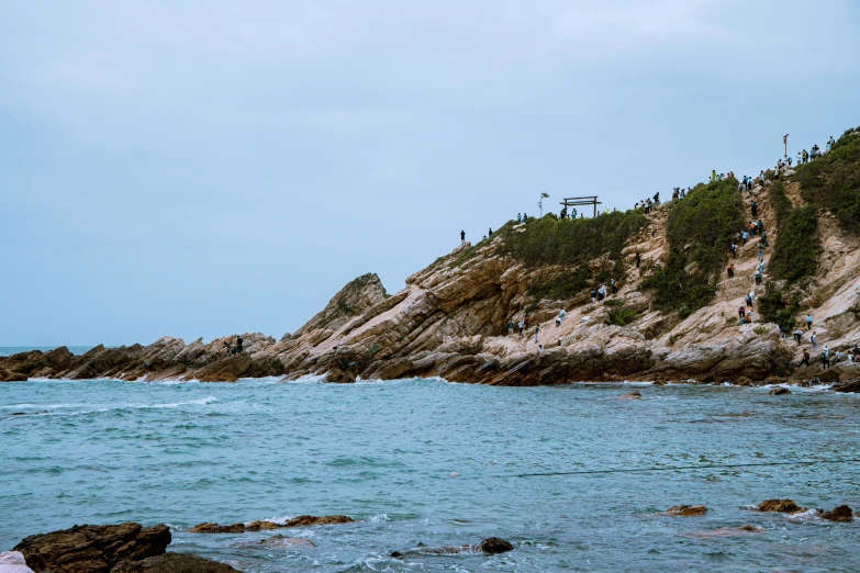 a group of people riding on the top of a rock in the ocean