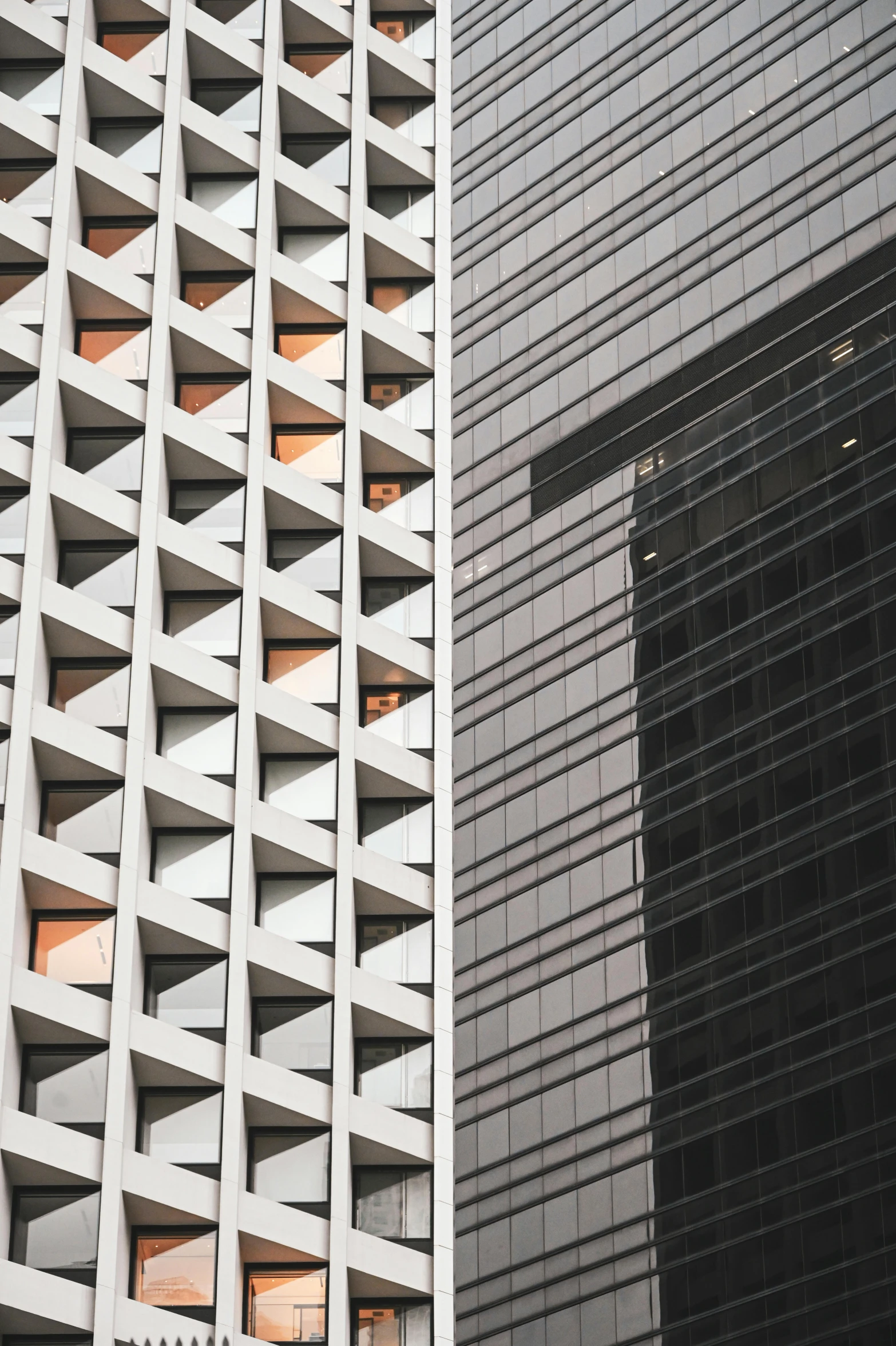 two very tall buildings with windows and glass sides