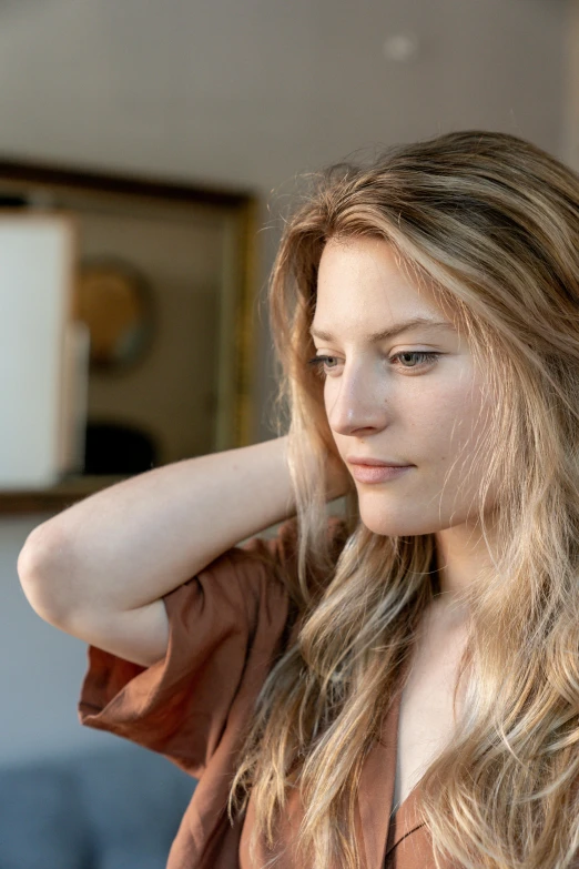 a beautiful young blonde woman wearing a brown shirt