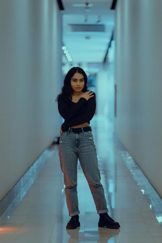 a woman standing in a long hallway next to a building