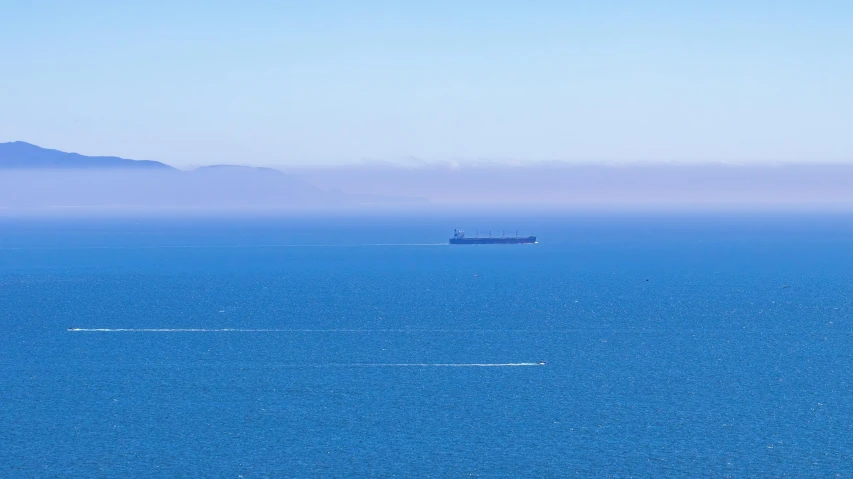 a boat is floating off in the blue ocean