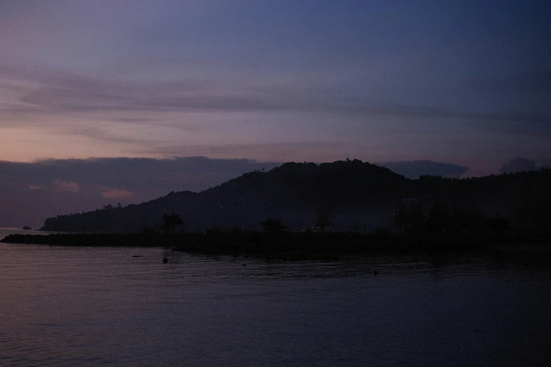 the water looks calm as the sun sets