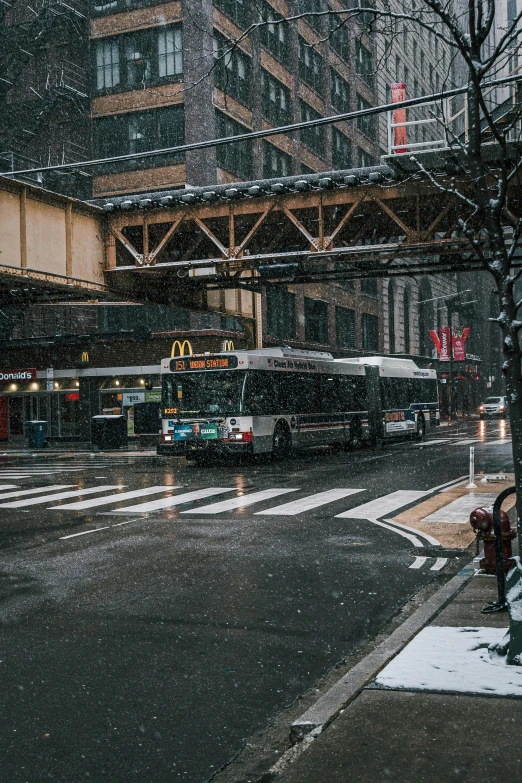 the city bus is traveling on the busy road in the winter