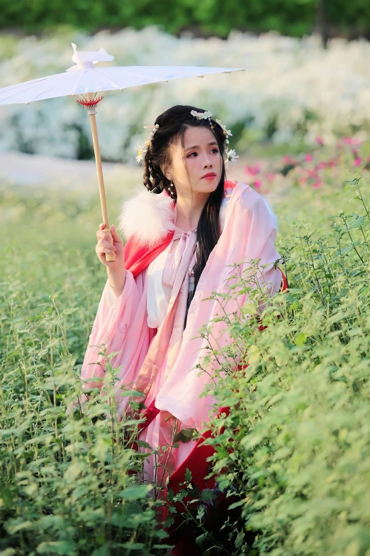 a young woman dressed in oriental dress holding an umbrella