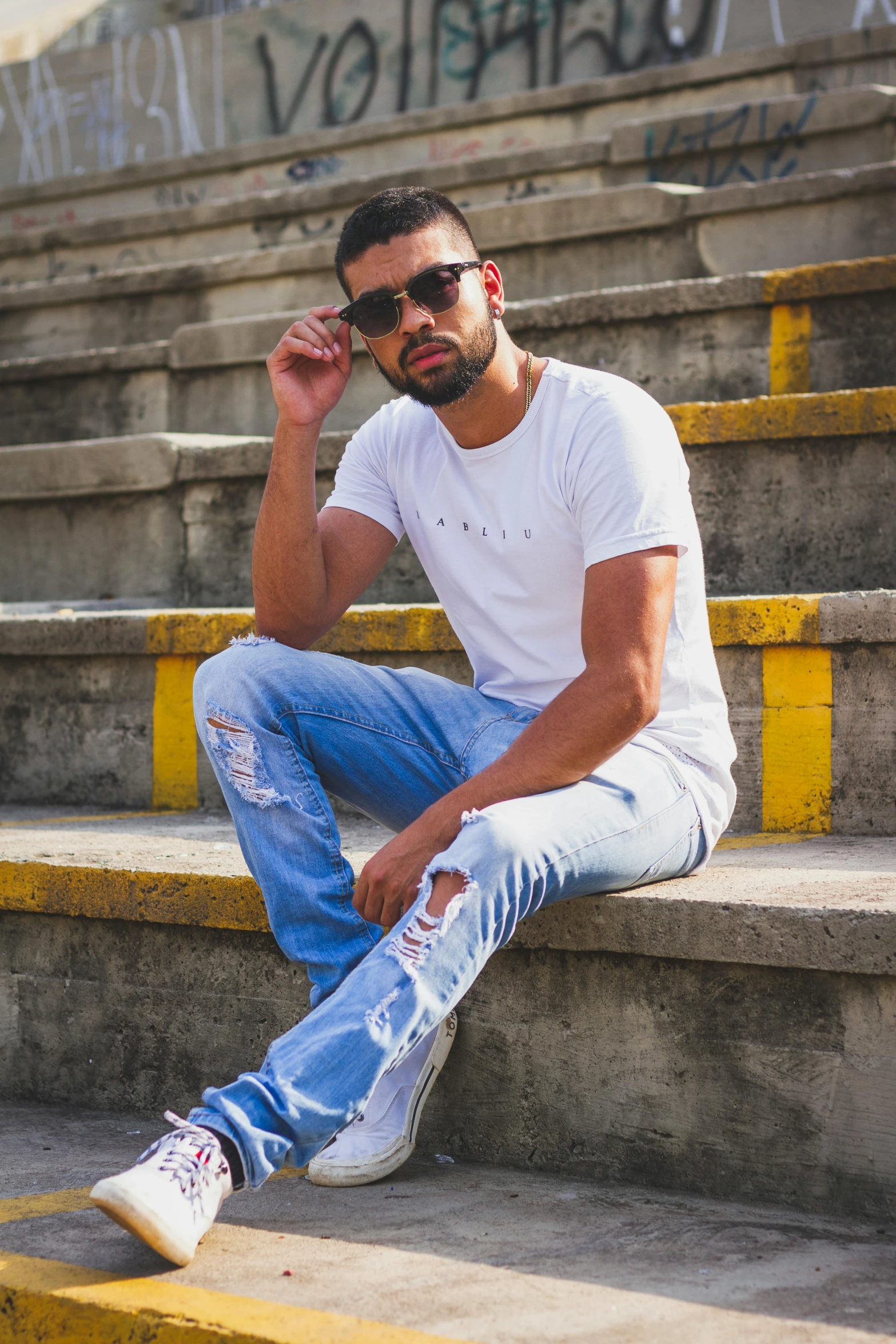 a man with sunglasses on sitting on some stairs