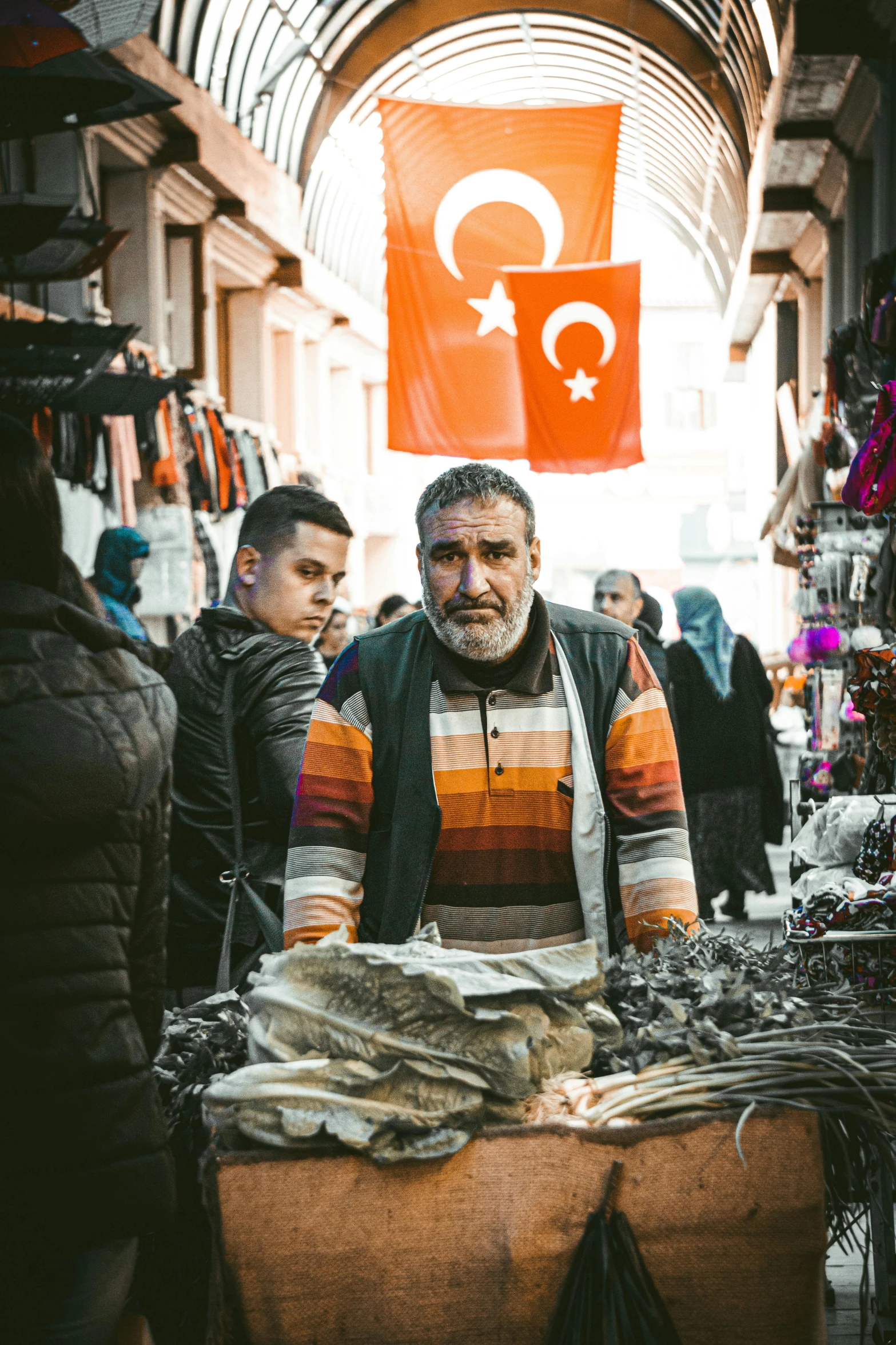 man looking out at the camera from inside a market place