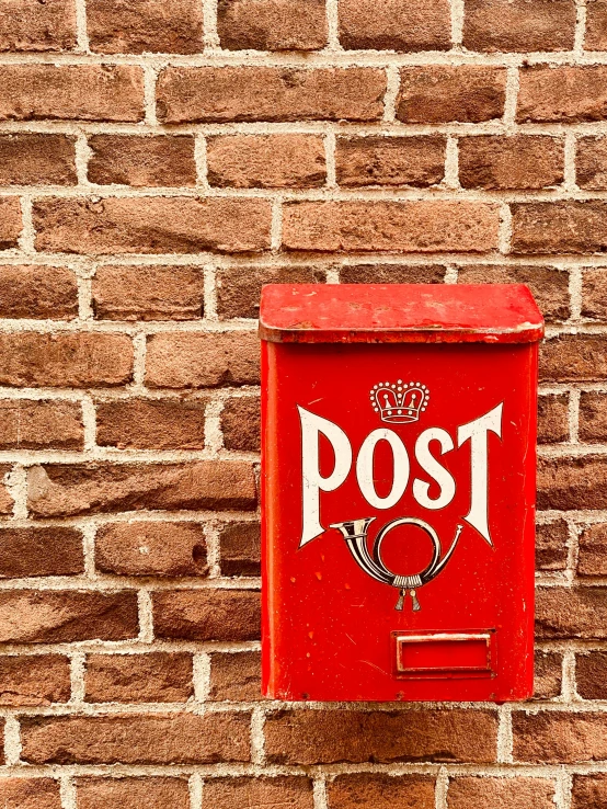 the box is painted red against a brick wall