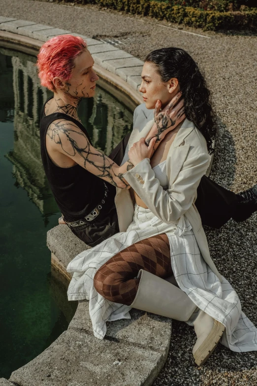 two women wearing white boots are talking in front of water