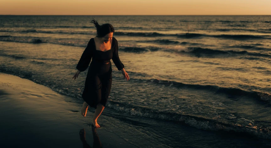 a woman walking on a beach in the water