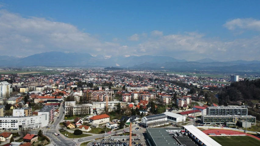 an aerial view of city with mountains and a river