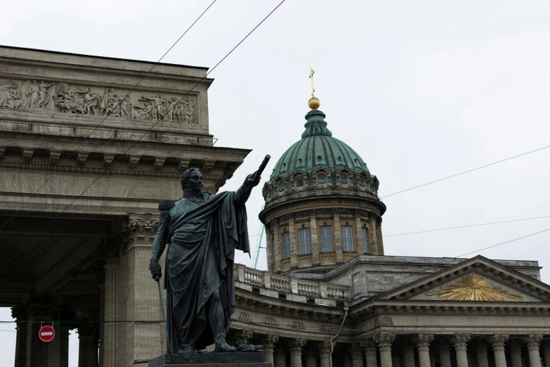 a statue with an outstretched hand near a large building