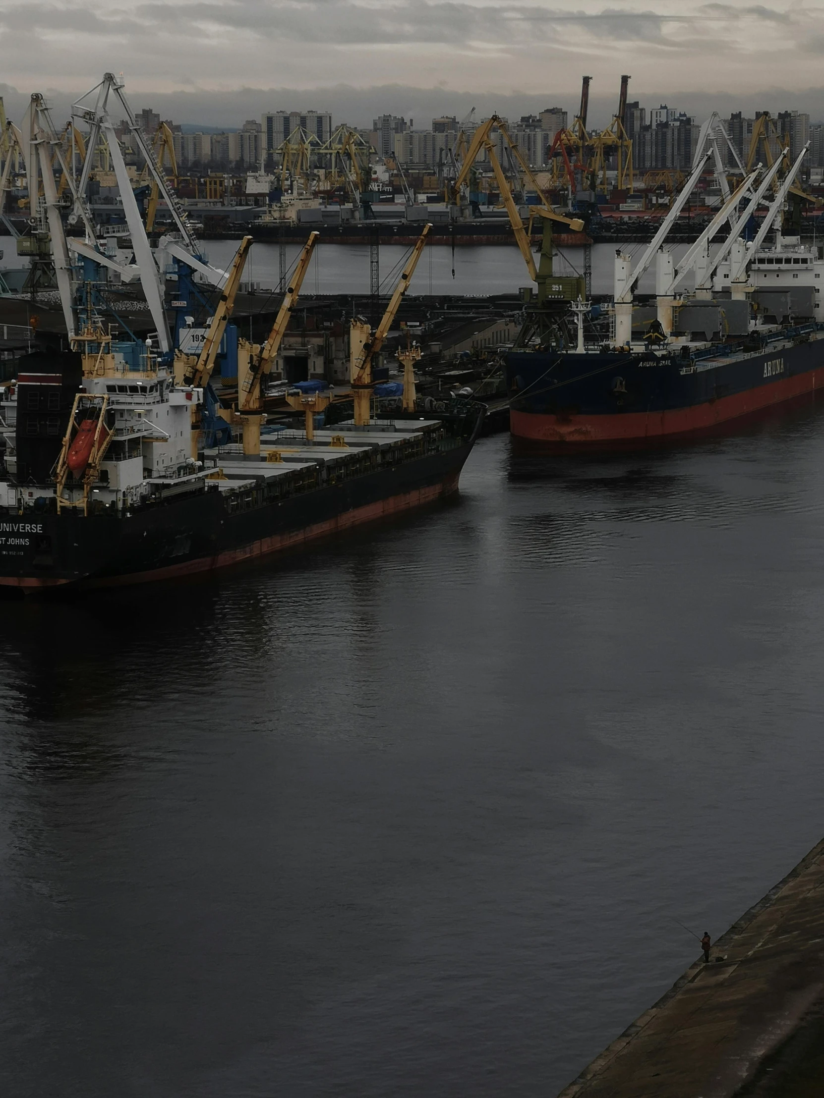 some docked ships in a harbor near a city