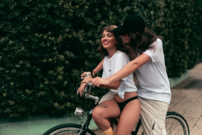 a man and woman riding on the back of a bicycle