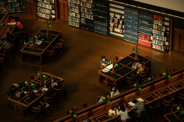 several people sitting at tables in an empty liry