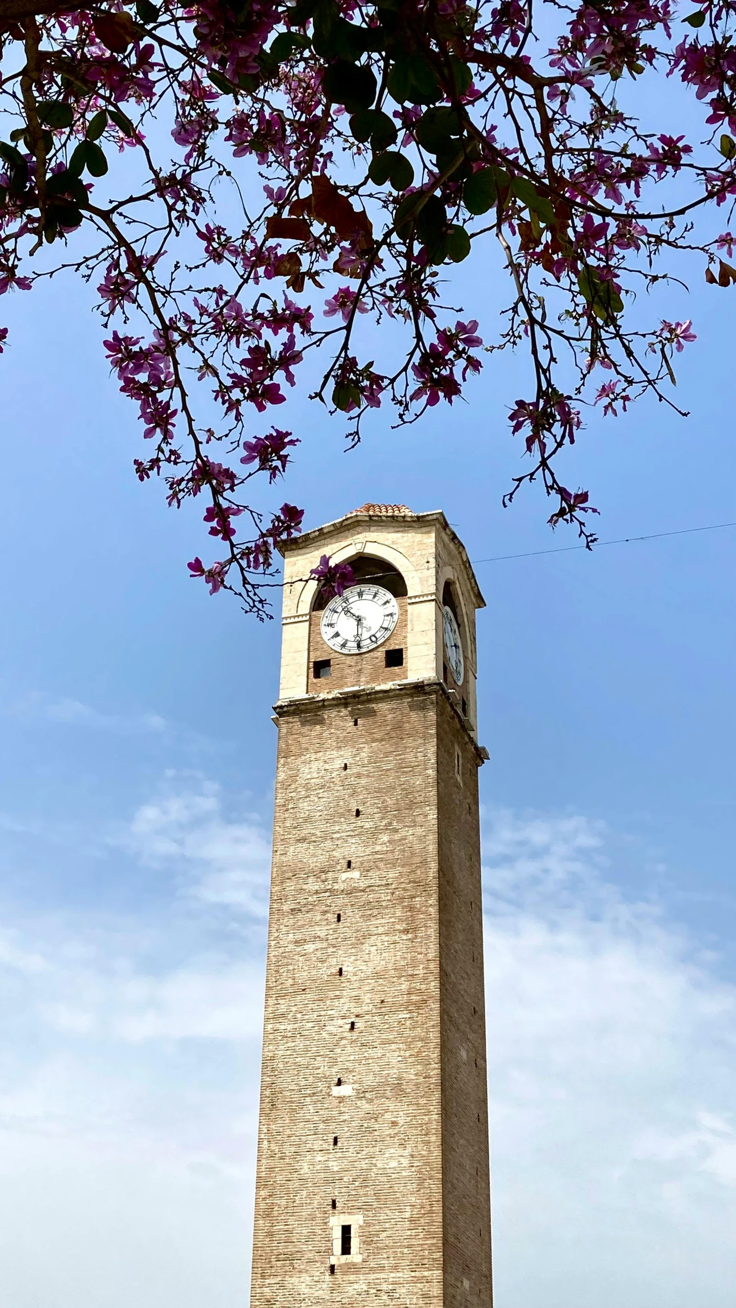 there is a clock on a stone tower that is in the air