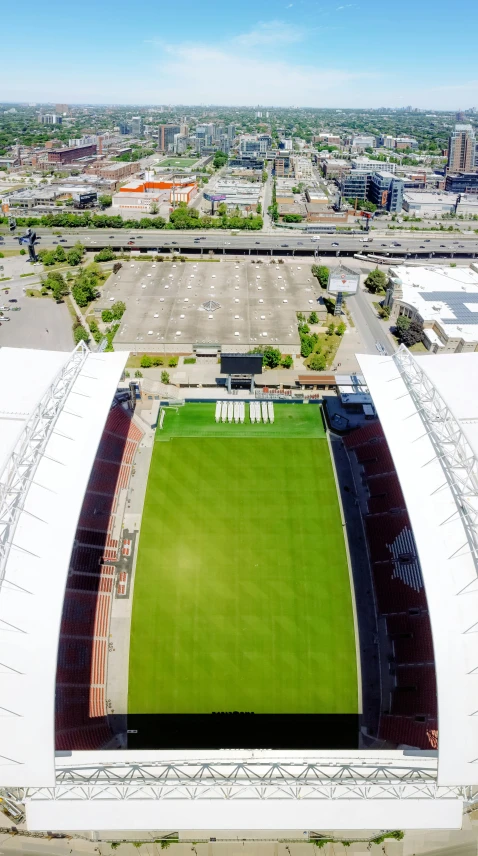 a large green field sitting next to a large stadium