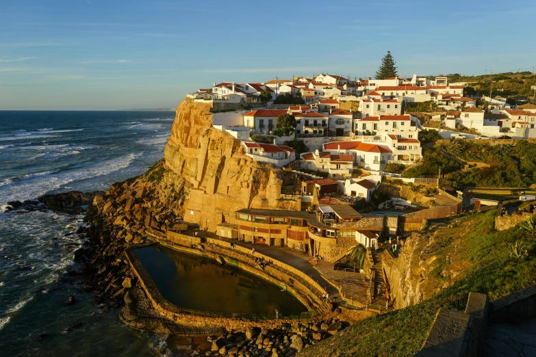 a long cliff with many buildings overlooking the ocean