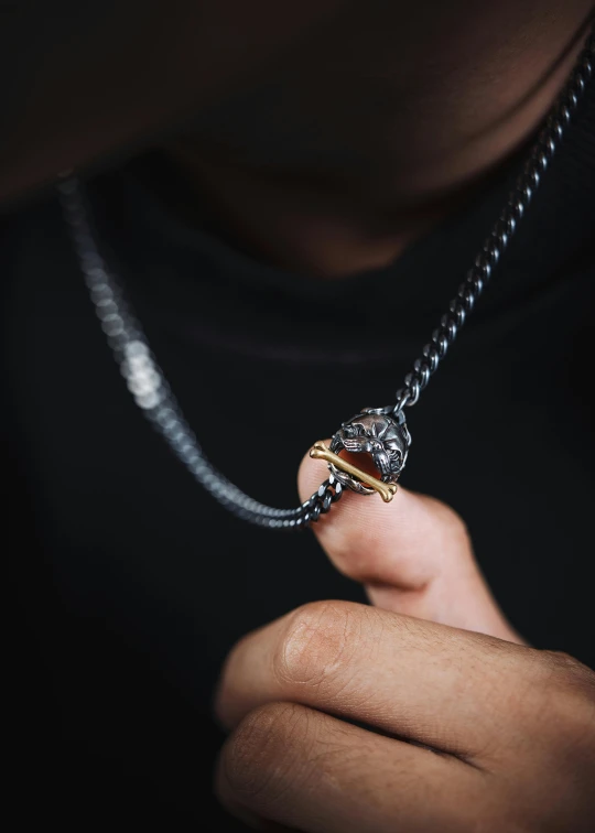 a man holding onto a necklace made of an elephant's head with two different colors on it