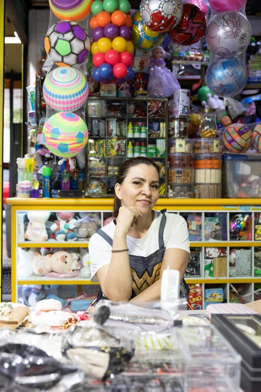 a woman is sitting in front of a shop looking out into the distance