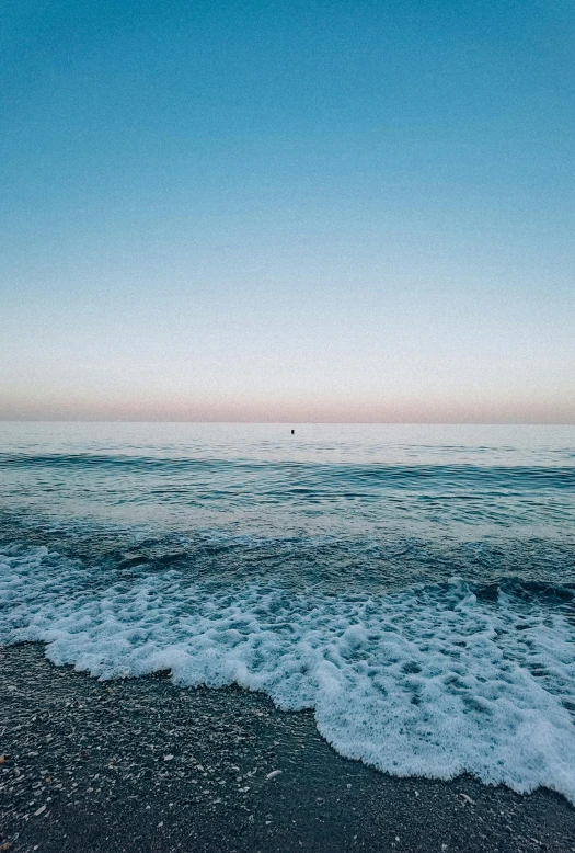 the ocean waves are hitting onto the shore