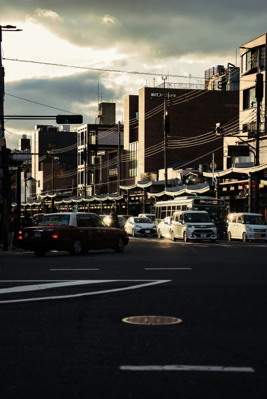 cars parked in the street of a city at sunset