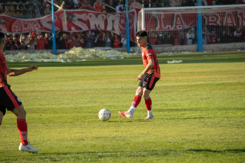 two soccer players are playing soccer in front of a crowd