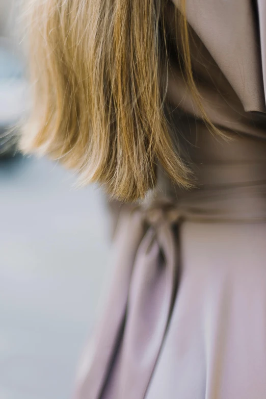 a person with blonde hair wearing a beige dress