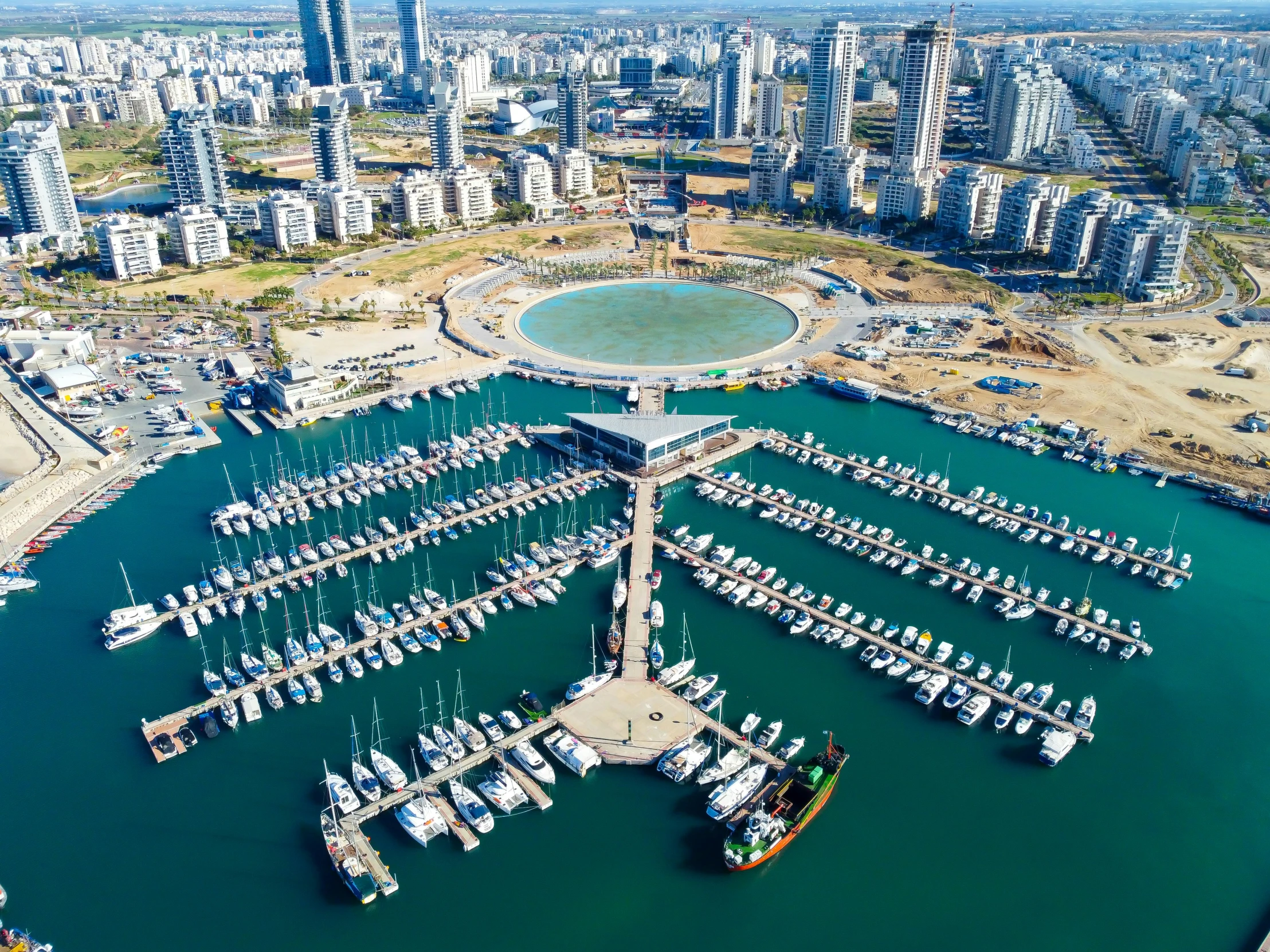 aerial view of boats in harbor with buildings and apartments in background