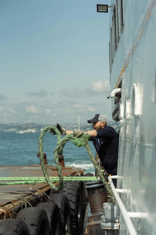 a man that is on a boat with some kind of rope