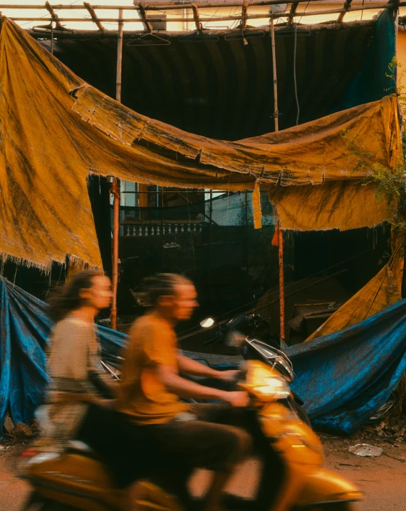 a man and woman riding a motorcycle down the street