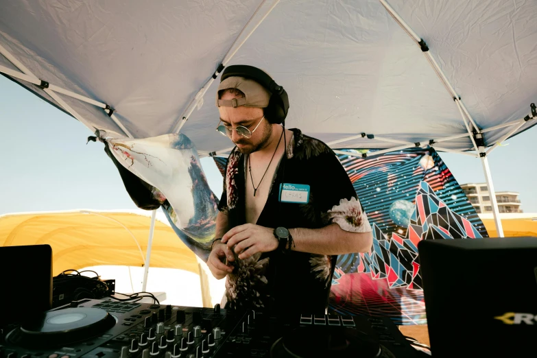 a man who is mixing music under a tent