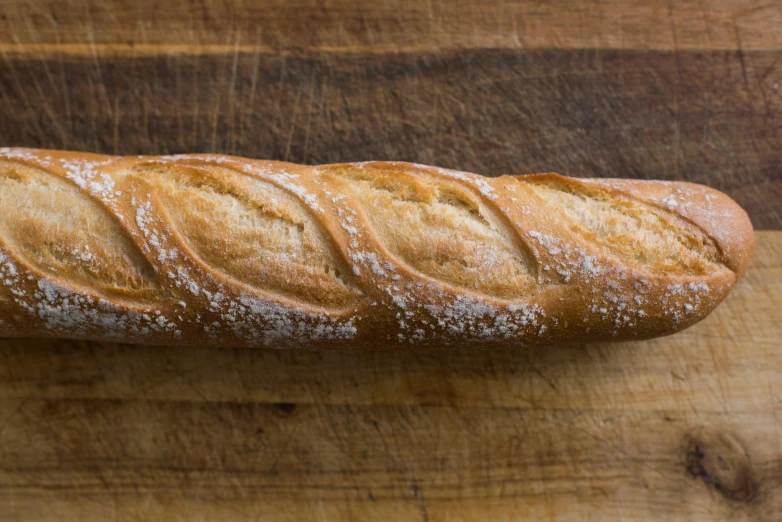 an unfinished loaf of bread sits on a  board