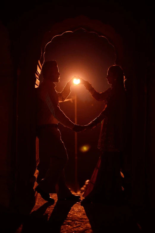 two people dancing on the street in the night