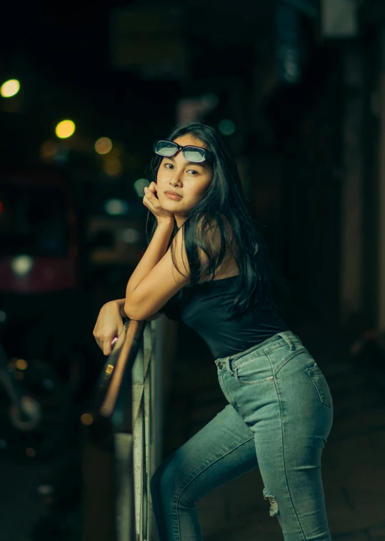 a girl leaning against a rail at night